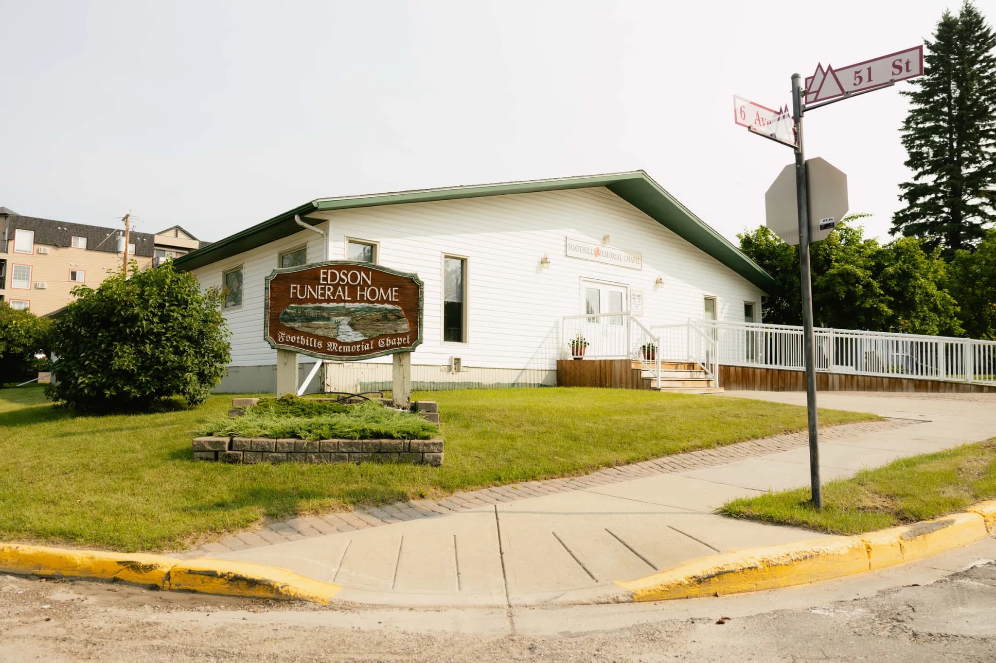 Edson Funeral Home and its carved Foothills Memorial Chapel sign at the corner of 6 Avenue and 51 Street in Edson, Alberta