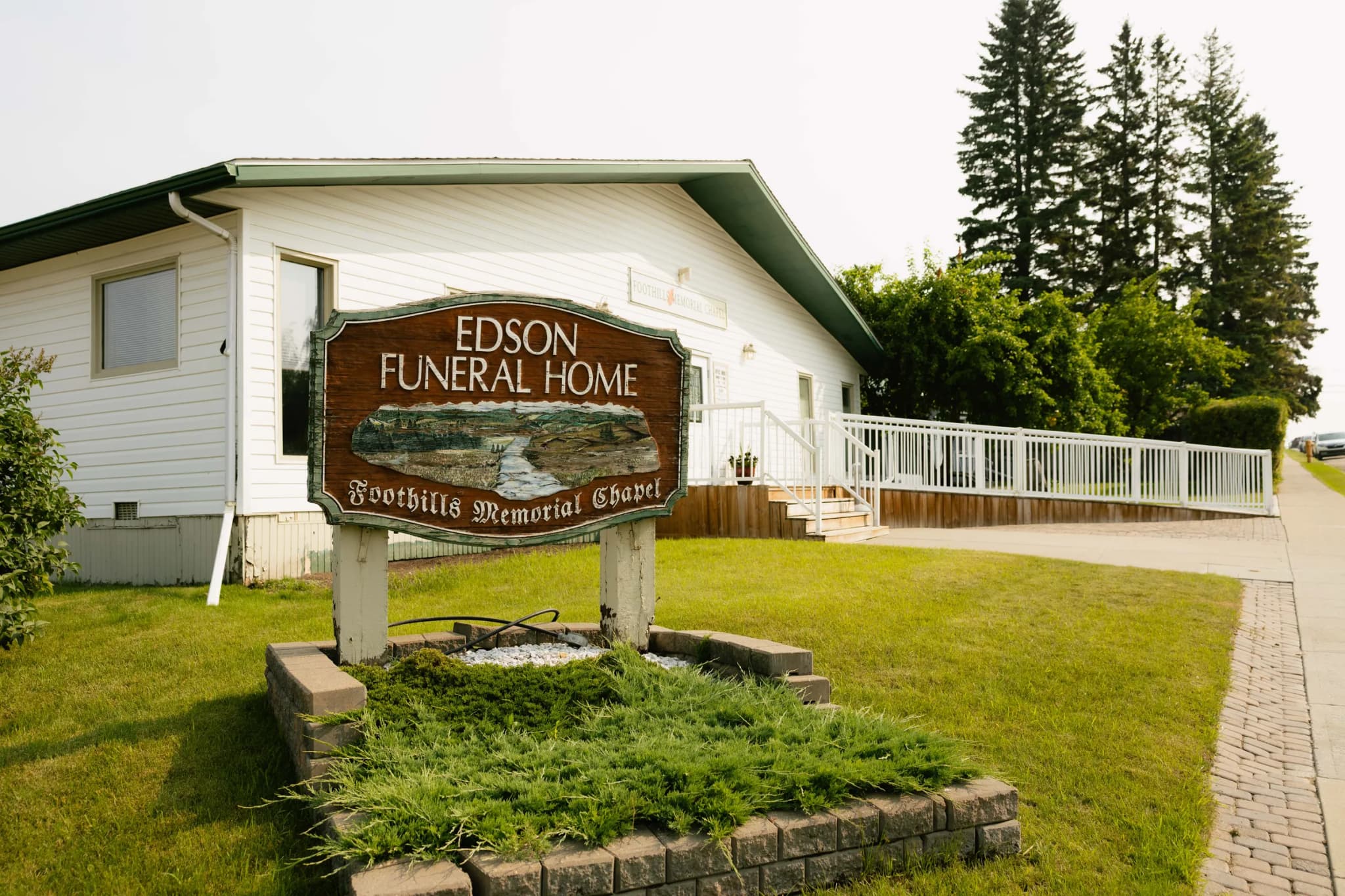 The carved Foothills Memorial Chapel sign in front of the funeral home